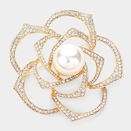 A gold-colored brooch with a pearl in the center, surrounded by smaller pearls and diamonds set in a geometric pattern.